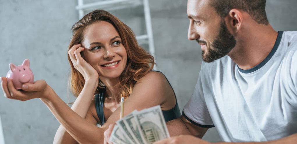 couple holding piggy bank and money